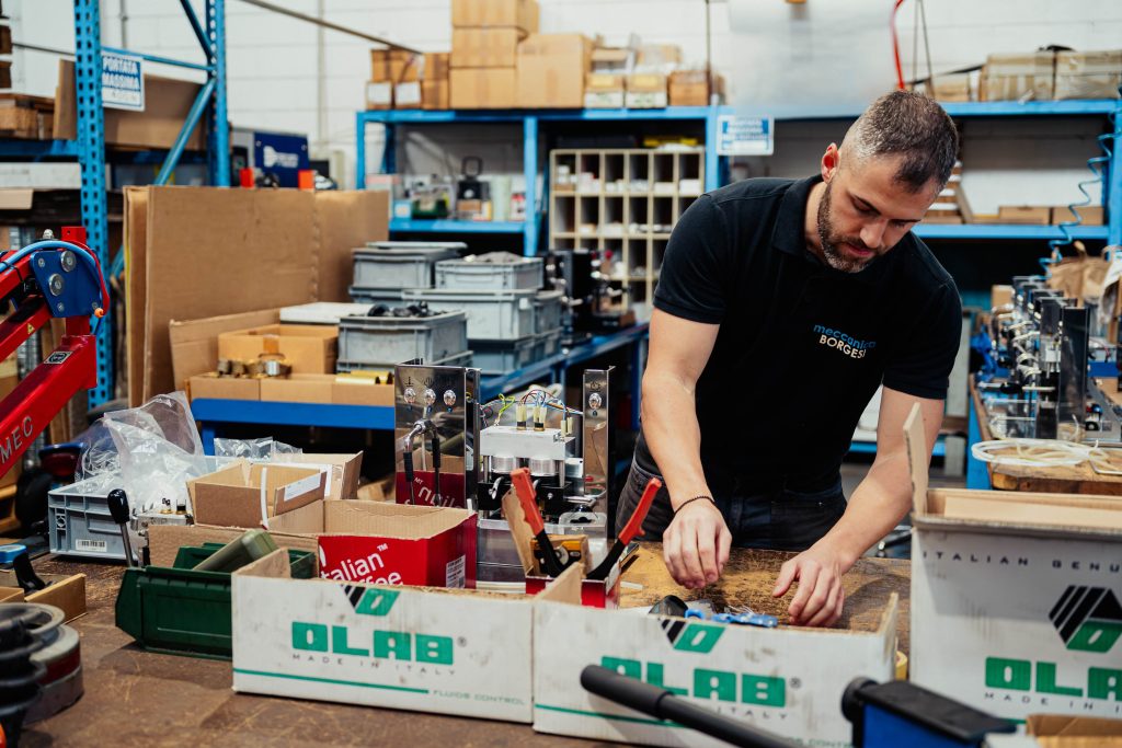Operaio assembla componenti meccaniche. Precisione e cura artigianale